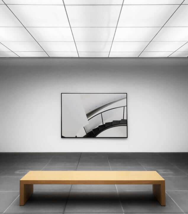 Gallery room showcasing a collection of paintings with a sculpture prominently placed in the center